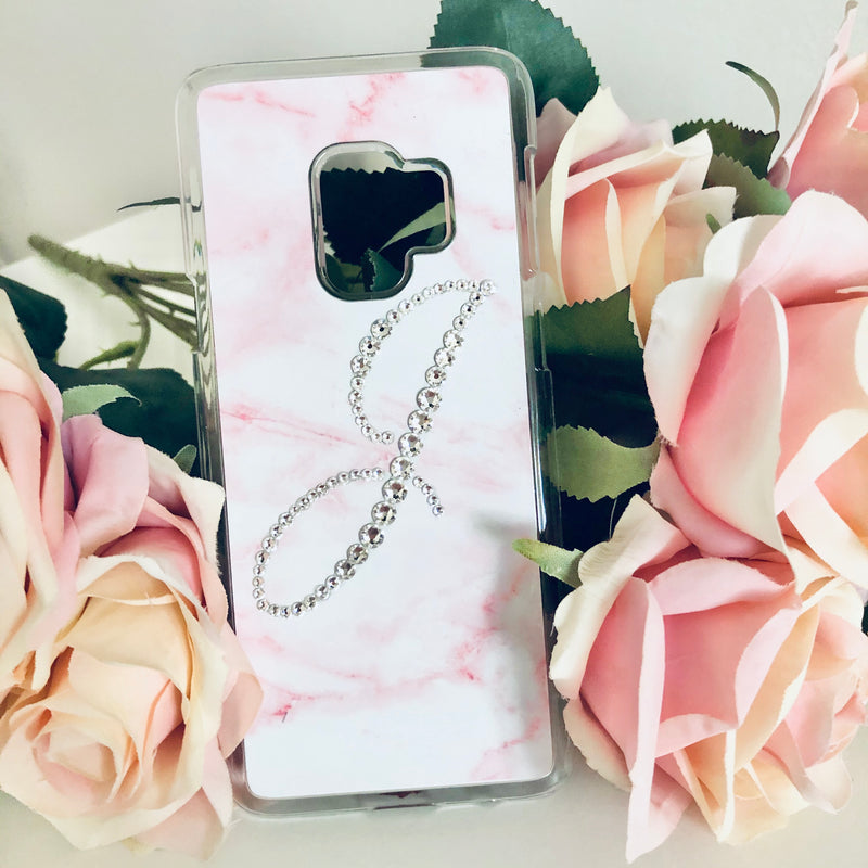 Phone case with pink and white marble design and rhinestone initial 'J' on pink roses